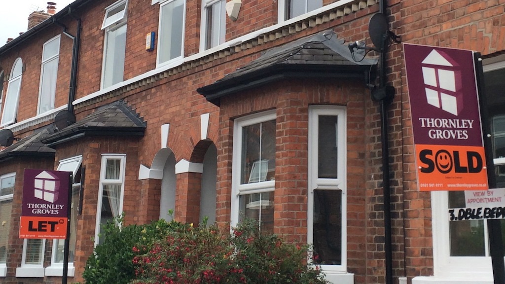 A row of red brick terraced houses, with two large "Thornley Groves" real estate signs in the foreground. One sign says "Let" and the other says "Sold."