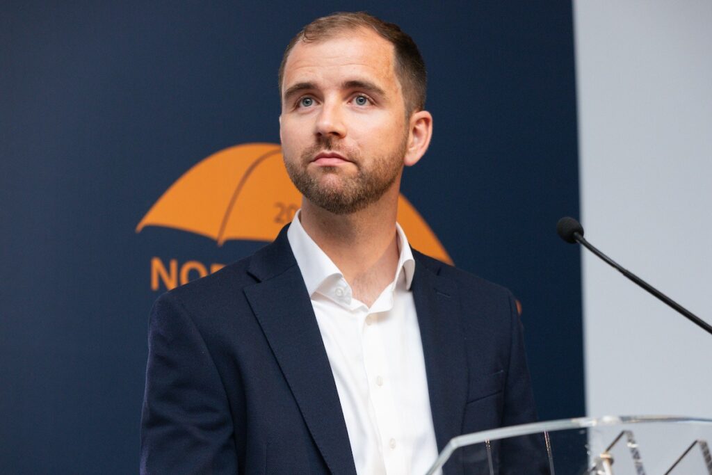 A man with a contemplative expression stood at an award's ceremony podium