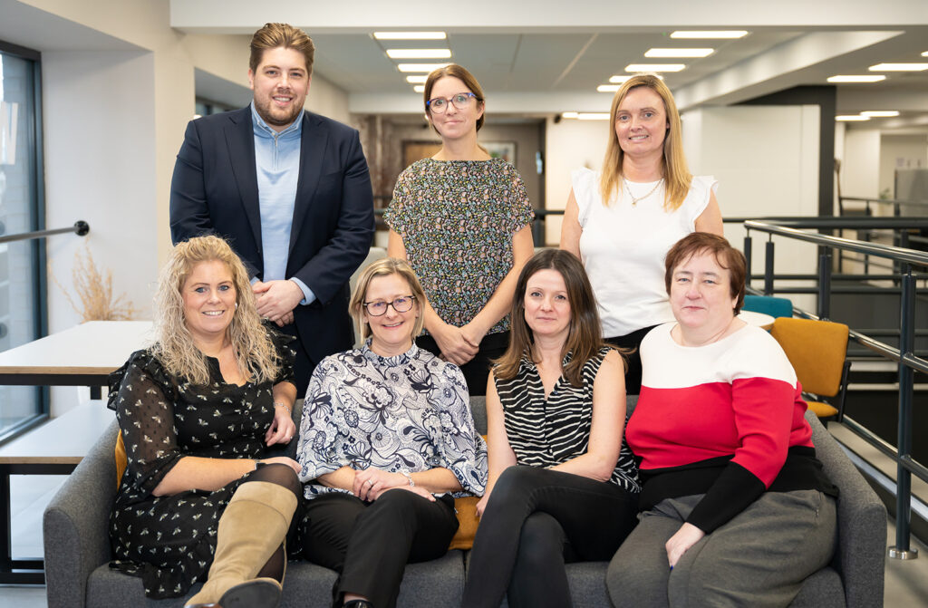 The business planning team made up of men and women sat for a group photo in their stockport office