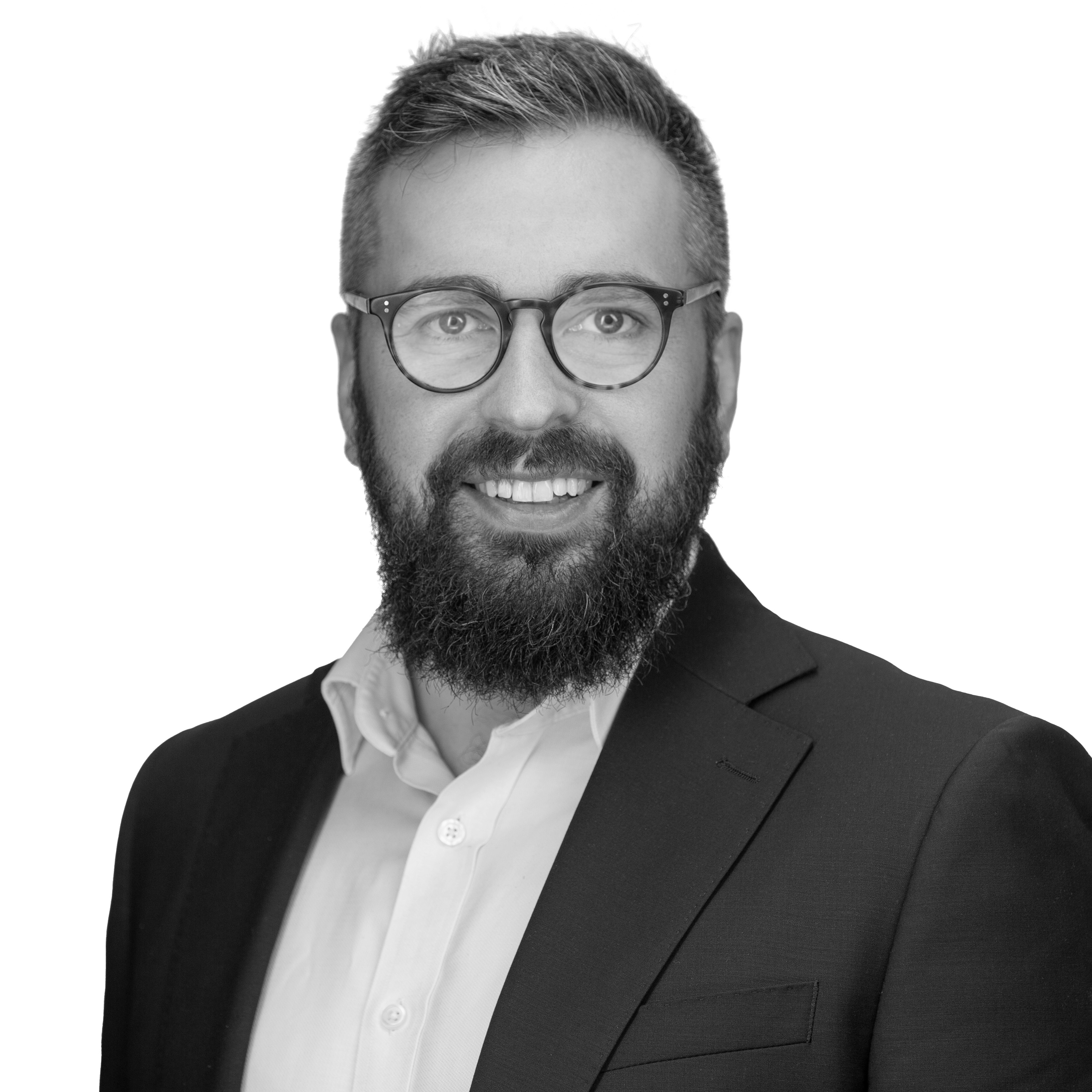 A black and white headshot image of a smiling man against a white backdrop