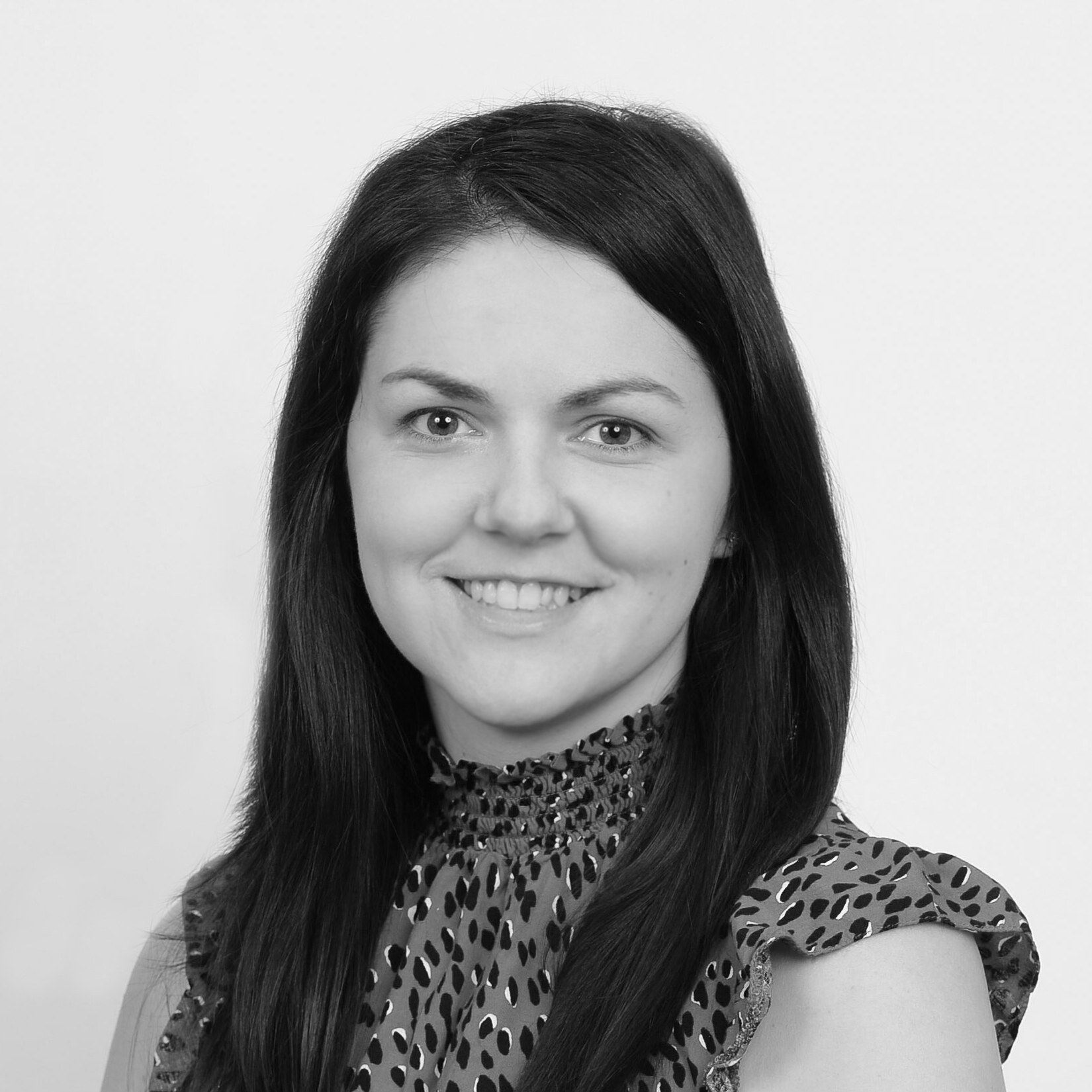 A headshot image of a smiling woman against a white backdrop