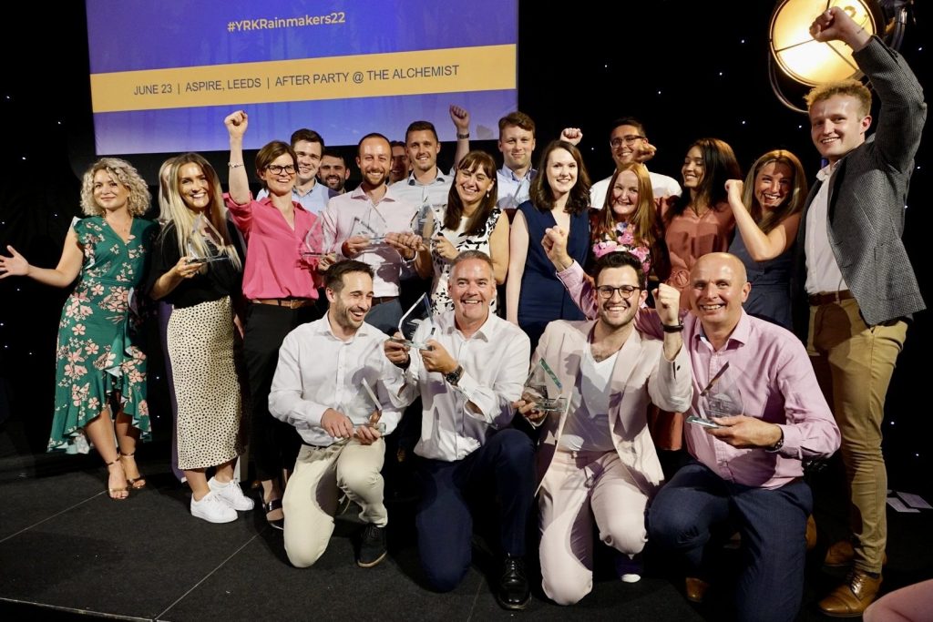 A diverse group celebrating their win at an award's ceremony