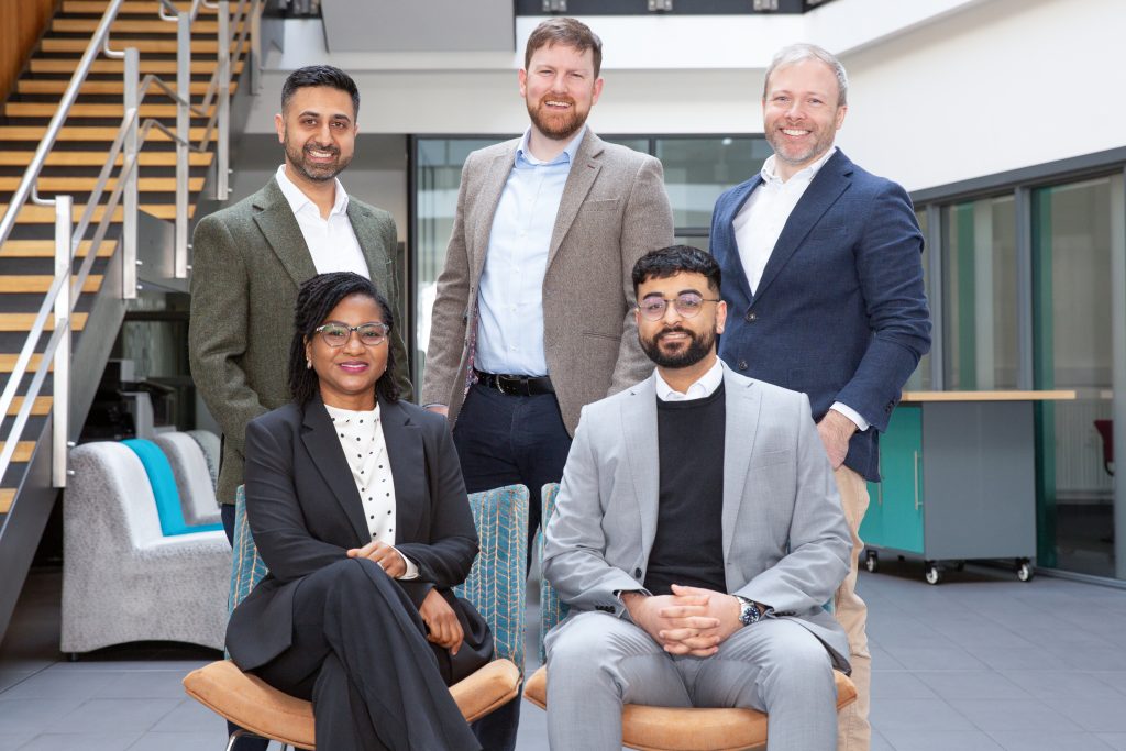 Happy, diverse team celebrating a project's success in an office.