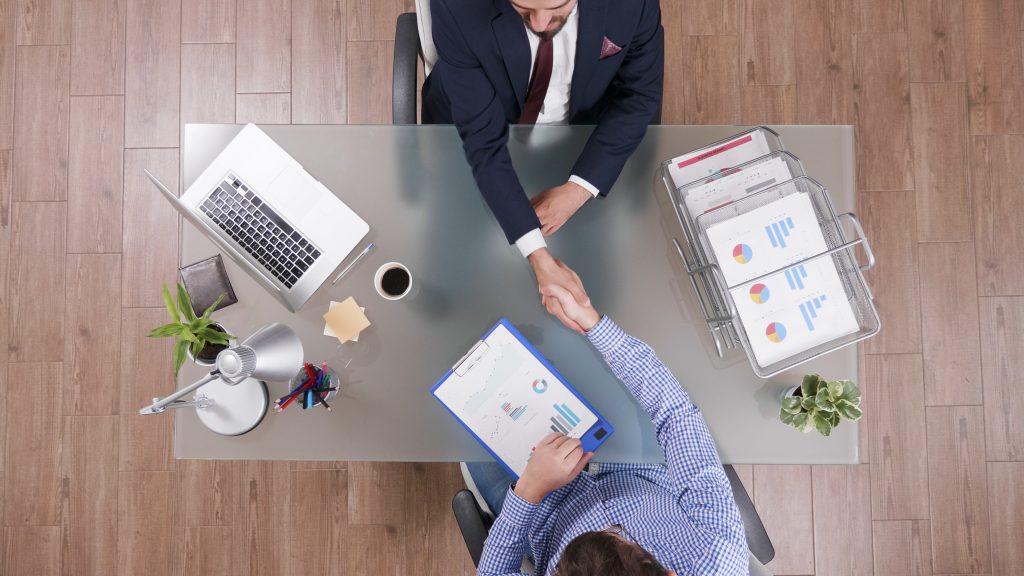 Two businessmen shaking hands during business negotiations in a start-up office